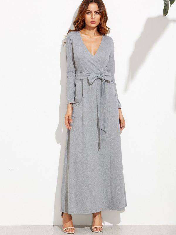 A long gray dress with a tie on the middle and a long sleeve